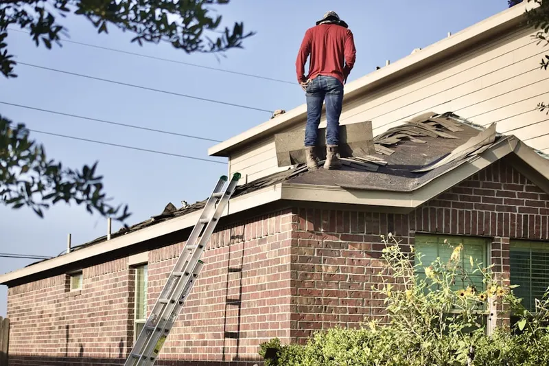Professional roofer working on a residential roof in Barker Land